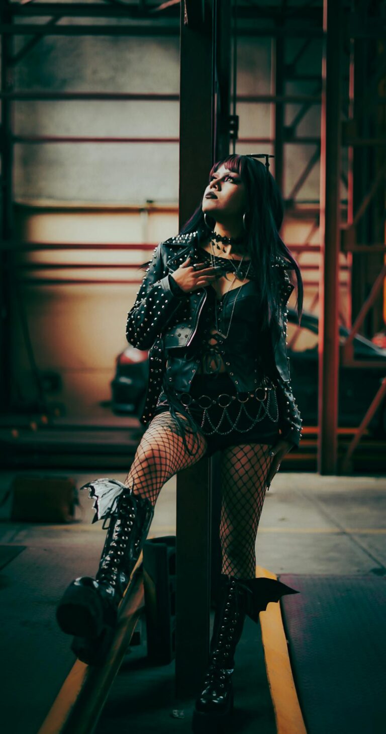 A woman in punk fashion poses in an industrial setting, exuding a bold and edgy vibe.
