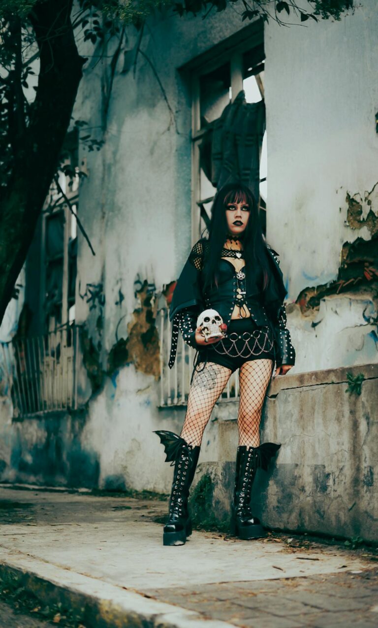 Dramatic gothic fashion portrait of a young woman in a decaying urban setting.